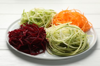 Photo of Different vegetable noodles on white wooden table, closeup. Vegetarian dish