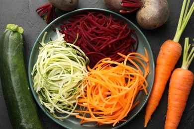 Photo of Different vegetable noodles on black table, flat lay. Vegetarian dish