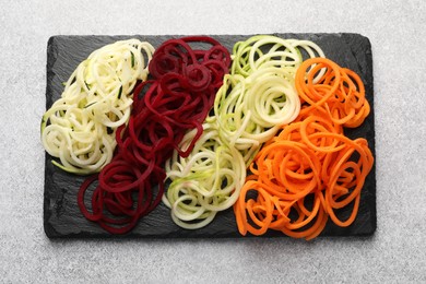 Photo of Different vegetable noodles on grey table, top view. Vegetarian dish