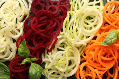 Photo of Different vegetable noodles with basil on table, flat lay. Vegetarian dish