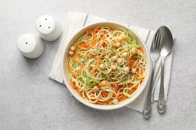 Photo of Tasty vegetable noodles with chickpeas served on grey table, flat lay. Vegetarian dish