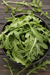 Photo of Fresh ripe green arugula leaves on dark wooden table, flat lay