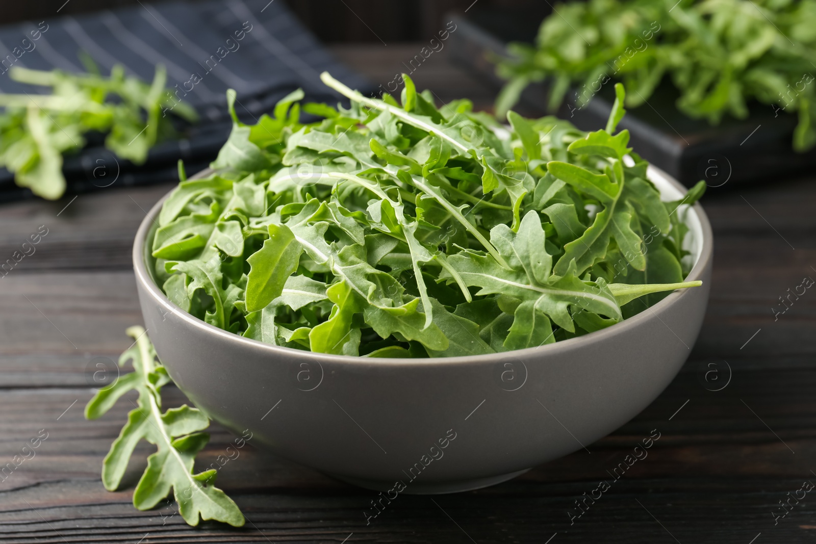 Fresh ripe green arugula leaves on dark wooden table, closeup Photo of Fresh ripe green arugula leaves on dark wooden table, closeup