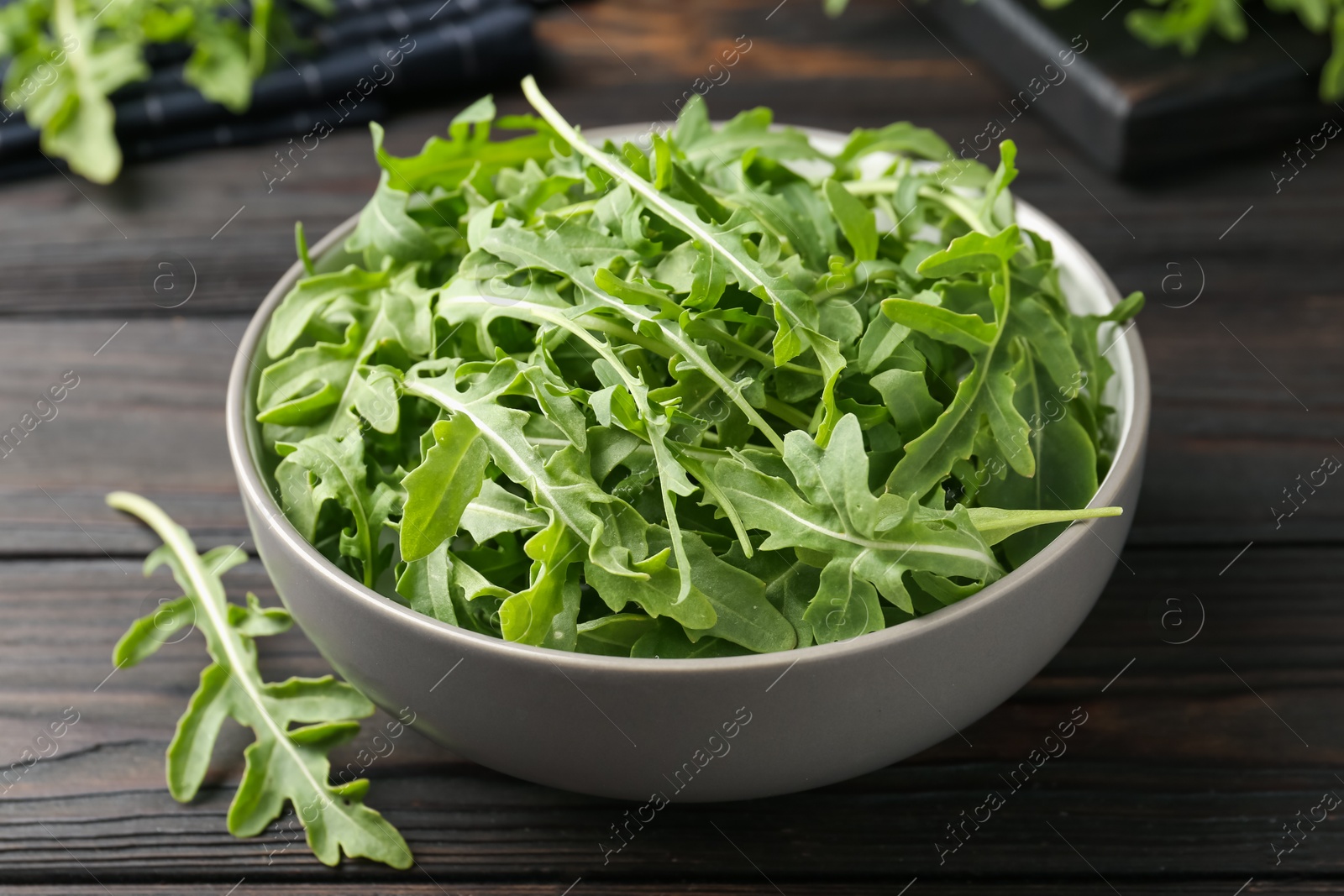 Fresh ripe green arugula leaves on dark wooden table, closeup Photo of Fresh ripe green arugula leaves on dark wooden table, closeup