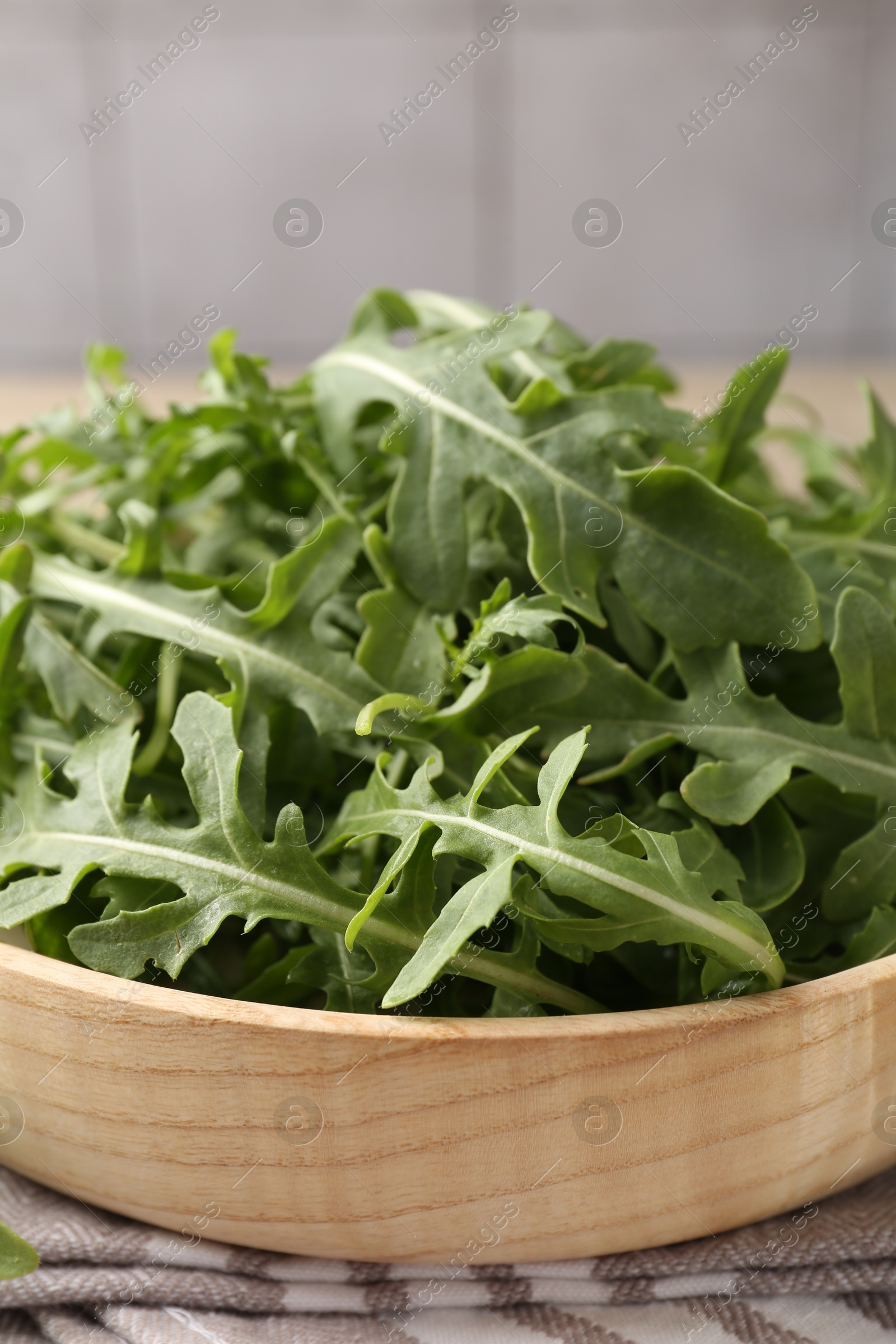 Fresh ripe green arugula leaves on light wooden table, closeup Photo of Fresh ripe green arugula leaves on light wooden table, closeup