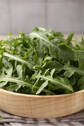 Photo of Fresh ripe green arugula leaves on light wooden table, closeup