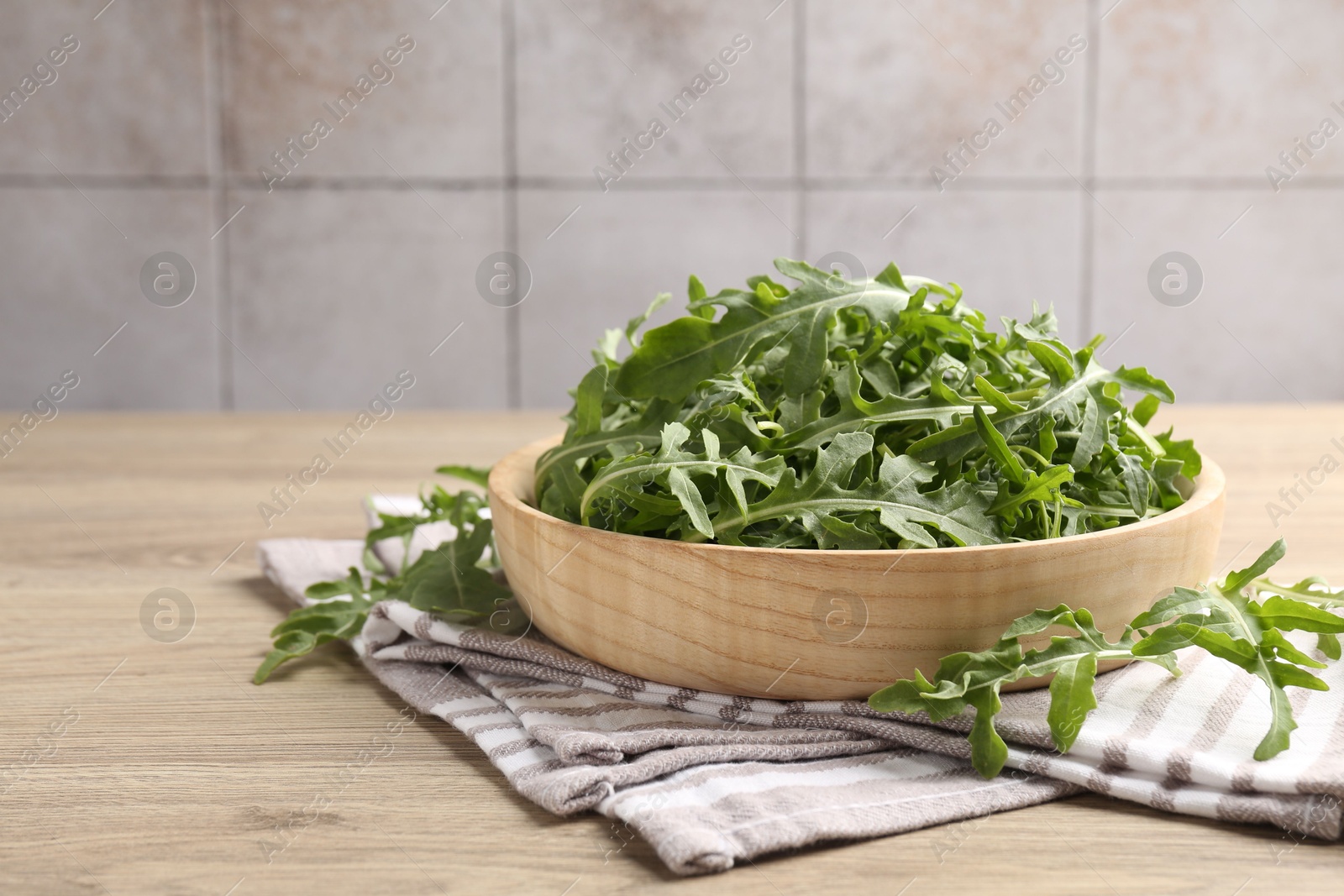 Fresh ripe green arugula leaves on light wooden table, closeup. Space for text Photo of Fresh ripe green arugula leaves on light wooden table, closeup. Space for text