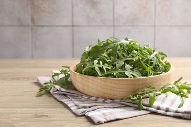 Photo of Fresh ripe green arugula leaves on light wooden table, closeup. Space for text