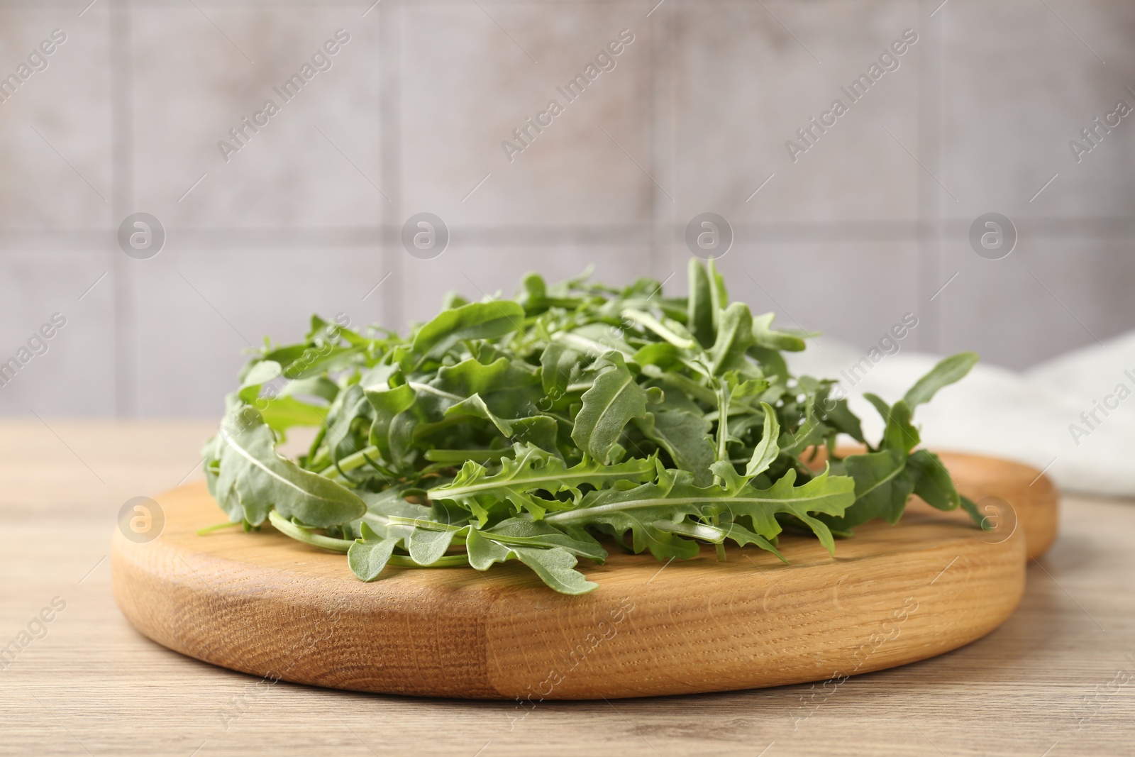 Fresh ripe green arugula leaves on light wooden table, closeup Photo of Fresh ripe green arugula leaves on light wooden table, closeup