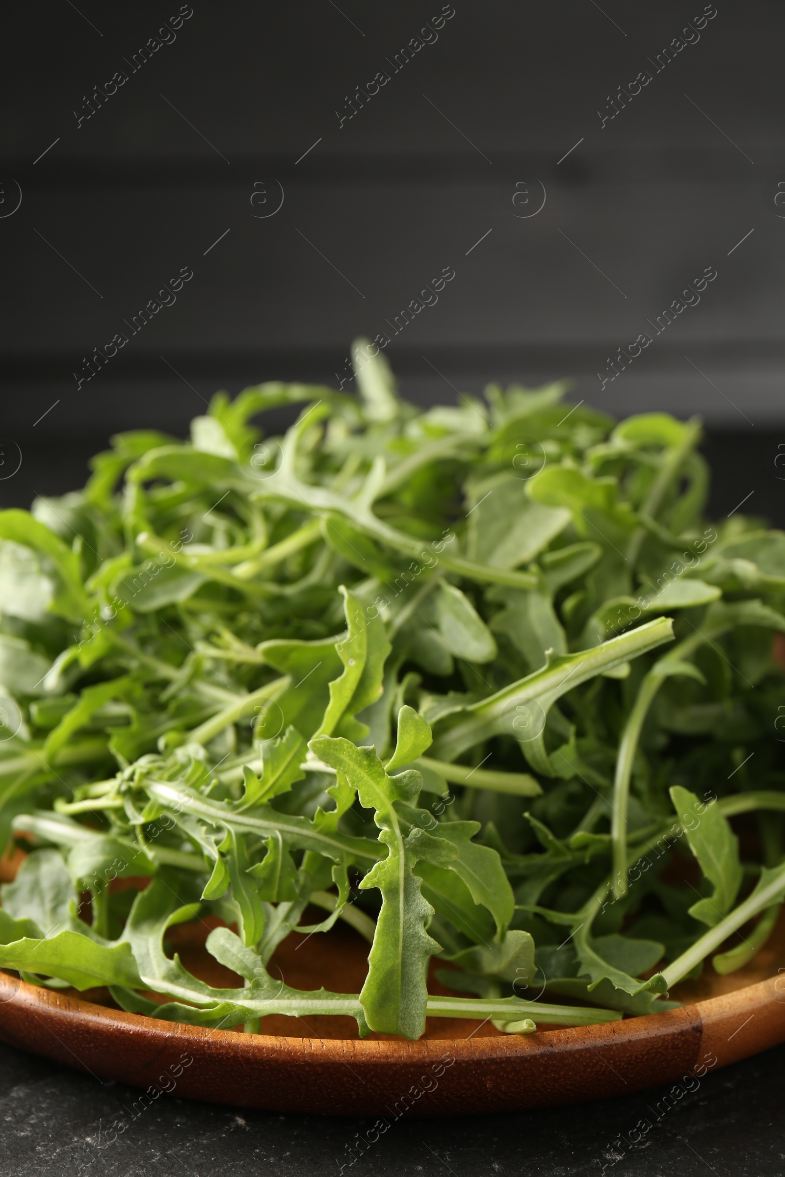 Fresh ripe green arugula leaves on black table, closeup Photo of Fresh ripe green arugula leaves on black table, closeup