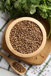 Photo of Coriander seeds and fresh cilantro on white table, top view