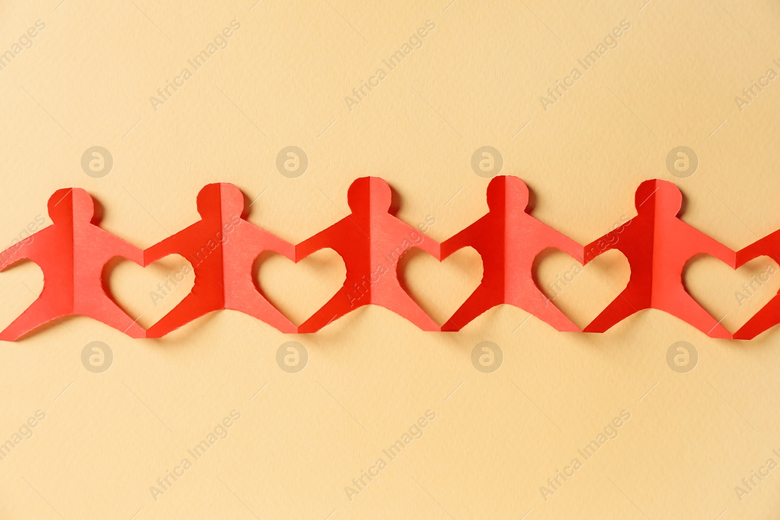 Paper figures of people holding hands on beige background, top view Photo of Paper figures of people holding hands on beige background, top view