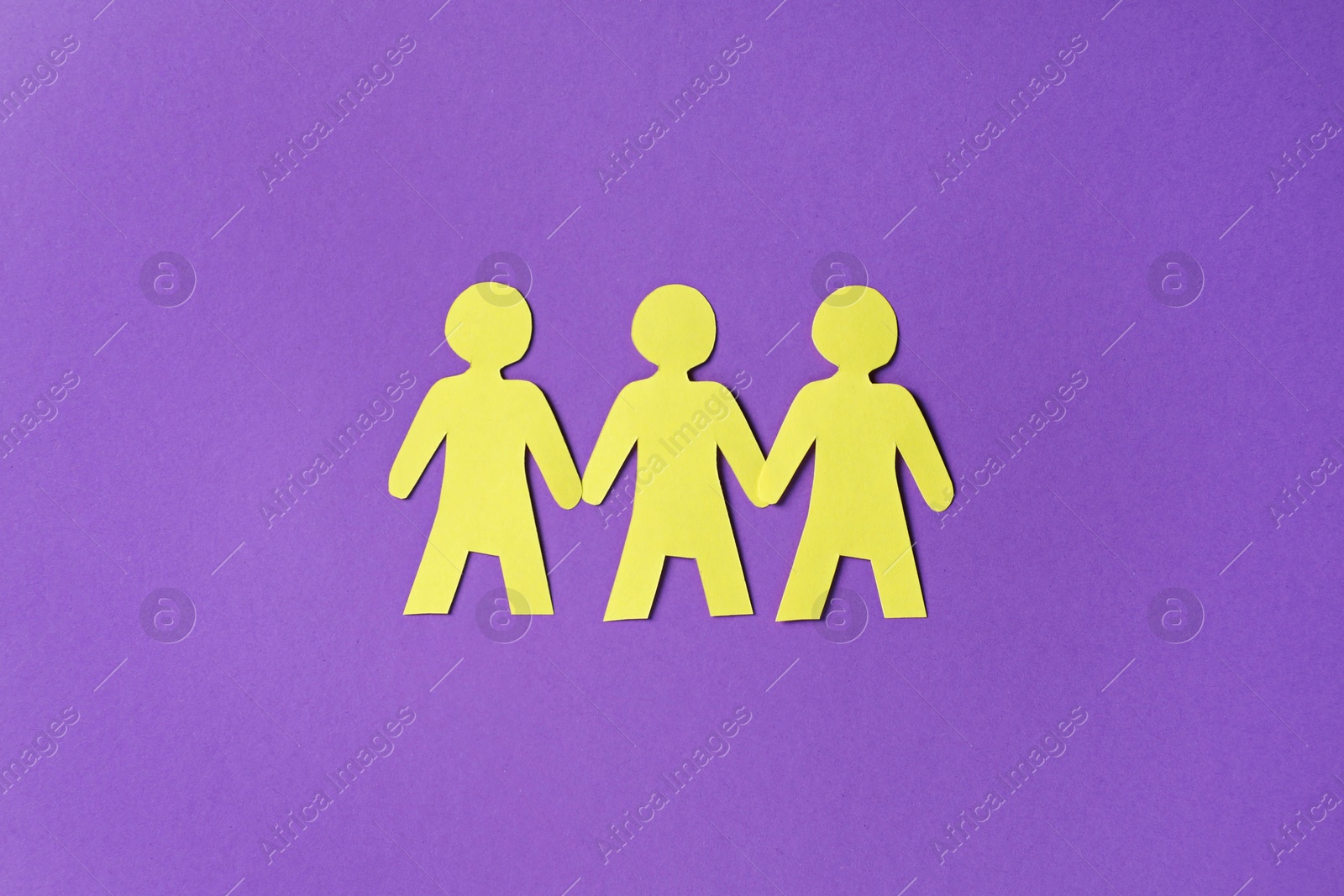 Paper figures of people holding hands on purple background, top view Photo of Paper figures of people holding hands on purple background, top view