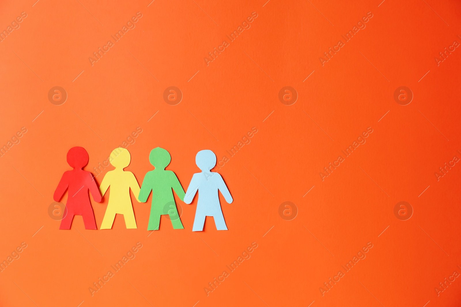 Paper figures of people holding hands on orange background, top view. Space for text Photo of Paper figures of people holding hands on orange background, top view. Space for text