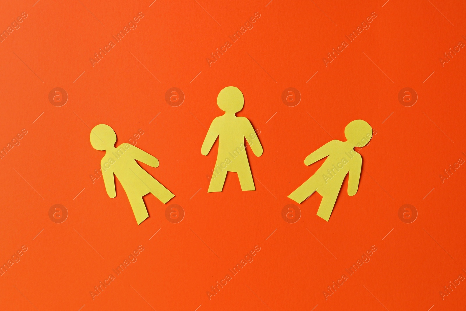Photo of Paper human figures on orange background, flat lay
