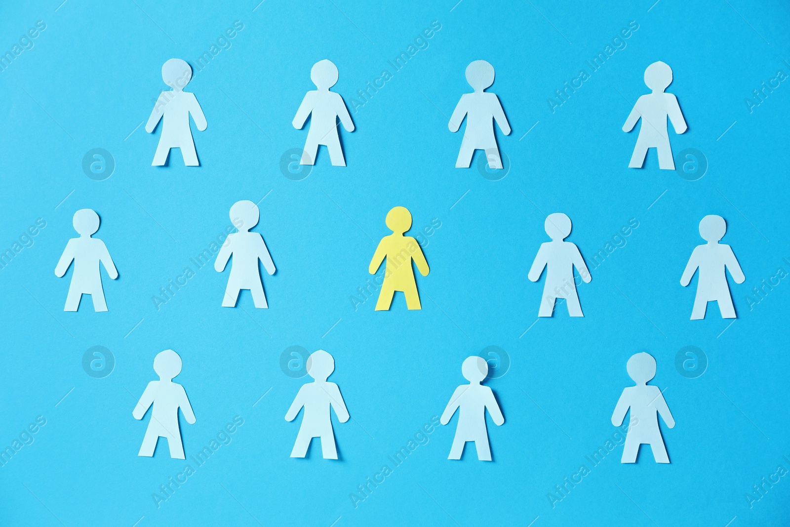 Paper human figures and yellow one on light blue background, flat lay Photo of Paper human figures and yellow one on light blue background, flat lay