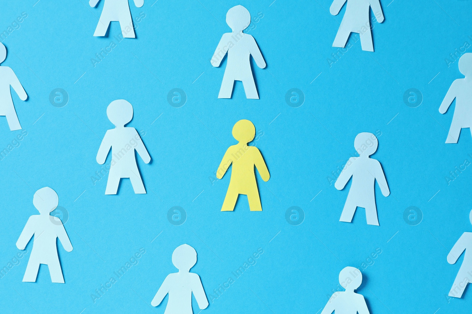 Paper human figures and yellow one on light blue background, flat lay Photo of Paper human figures and yellow one on light blue background, flat lay