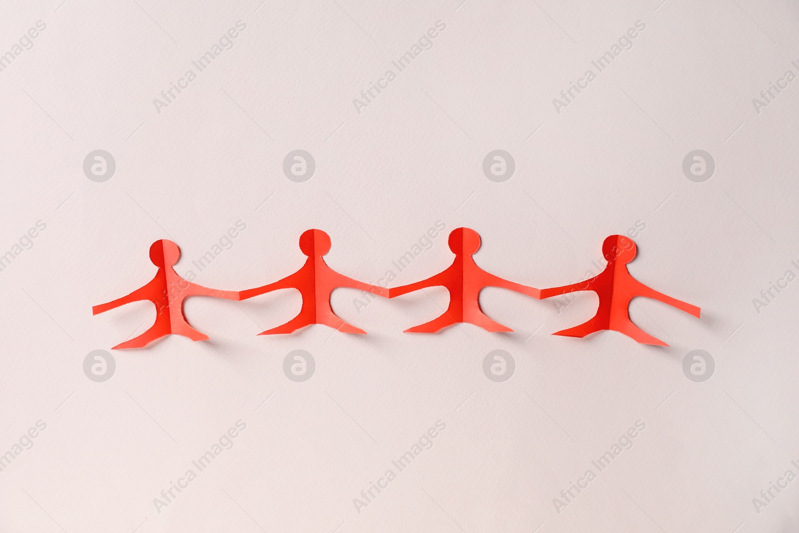 Paper figures of people holding hands on beige background, top view Photo of Paper figures of people holding hands on beige background, top view