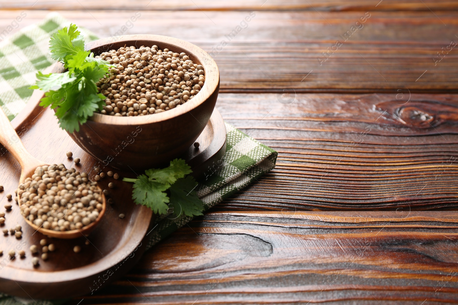 Coriander seeds and fresh cilantro sprigs on wooden table, closeup. Space for text Photo of Coriander seeds and fresh cilantro sprigs on wooden table, closeup. Space for text