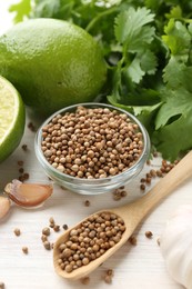 Photo of Coriander seeds, fresh cilantro, lime and garlic on light wooden table, closeup