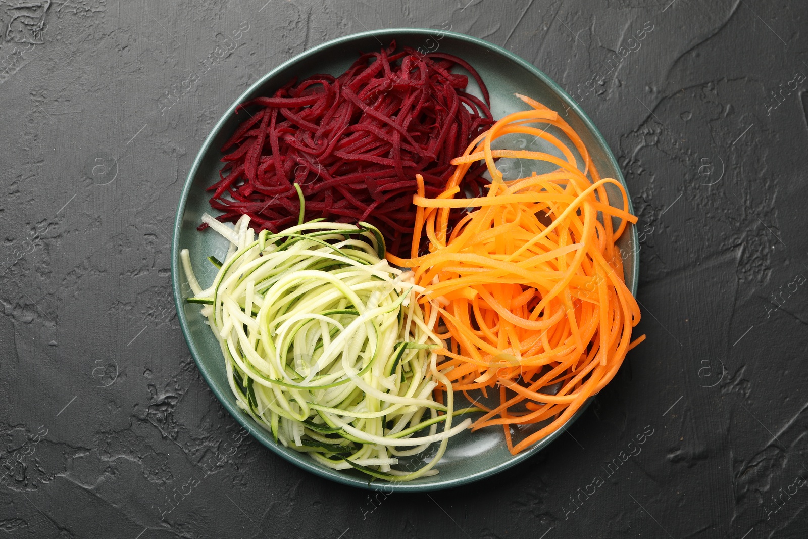 Different vegetable noodles on black table, top view. Vegetarian dish Photo of Different vegetable noodles on black table, top view. Vegetarian dish