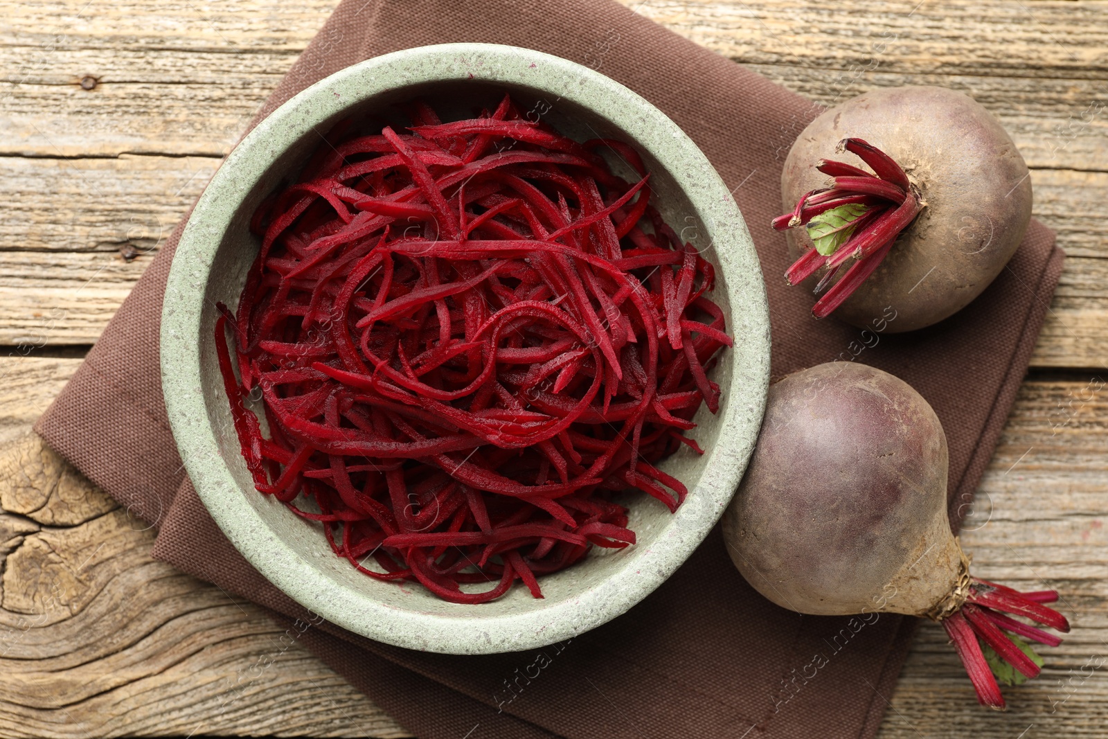 Raw beetroot noodles and fresh vegetables on wooden table, flat lay. Vegetarian dish Photo of Raw beetroot noodles and fresh vegetables on wooden table, flat lay. Vegetarian dish