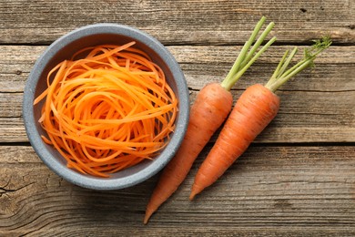Photo of Raw beetroot noodles and fresh vegetables on wooden table, flat lay. Vegetarian dish