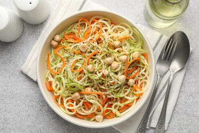 Photo of Tasty vegetable noodles with chickpeas served on grey table, flat lay. Vegetarian dish
