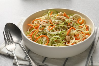Photo of Tasty vegetable noodles with chickpeas served on grey table, closeup. Vegetarian dish