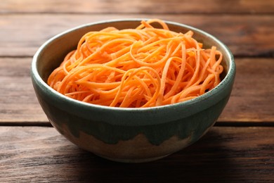 Photo of Vegetable noodles in bowl on wooden table, closeup