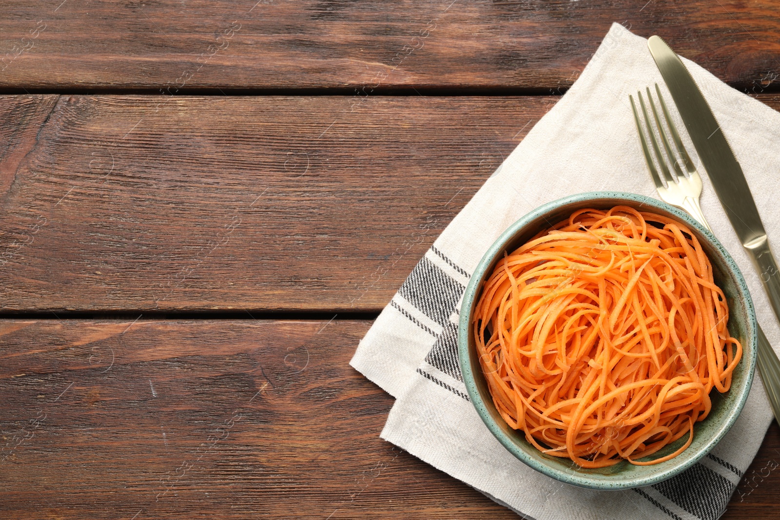Photo of Vegetable noodles served on wooden table, top view. Space for text