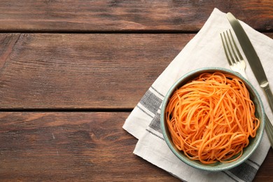 Photo of Vegetable noodles served on wooden table, top view. Space for text