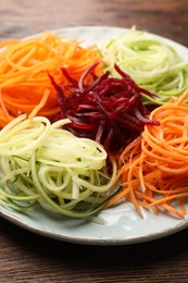 Photo of Different vegetable noodles on wooden table, closeup