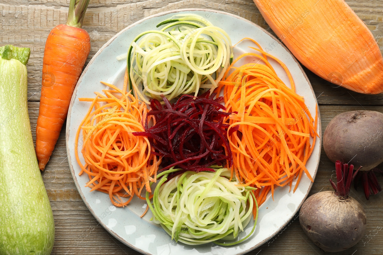 Different noodles and vegetables on wooden table, flat lay Photo of Different noodles and vegetables on wooden table, flat lay