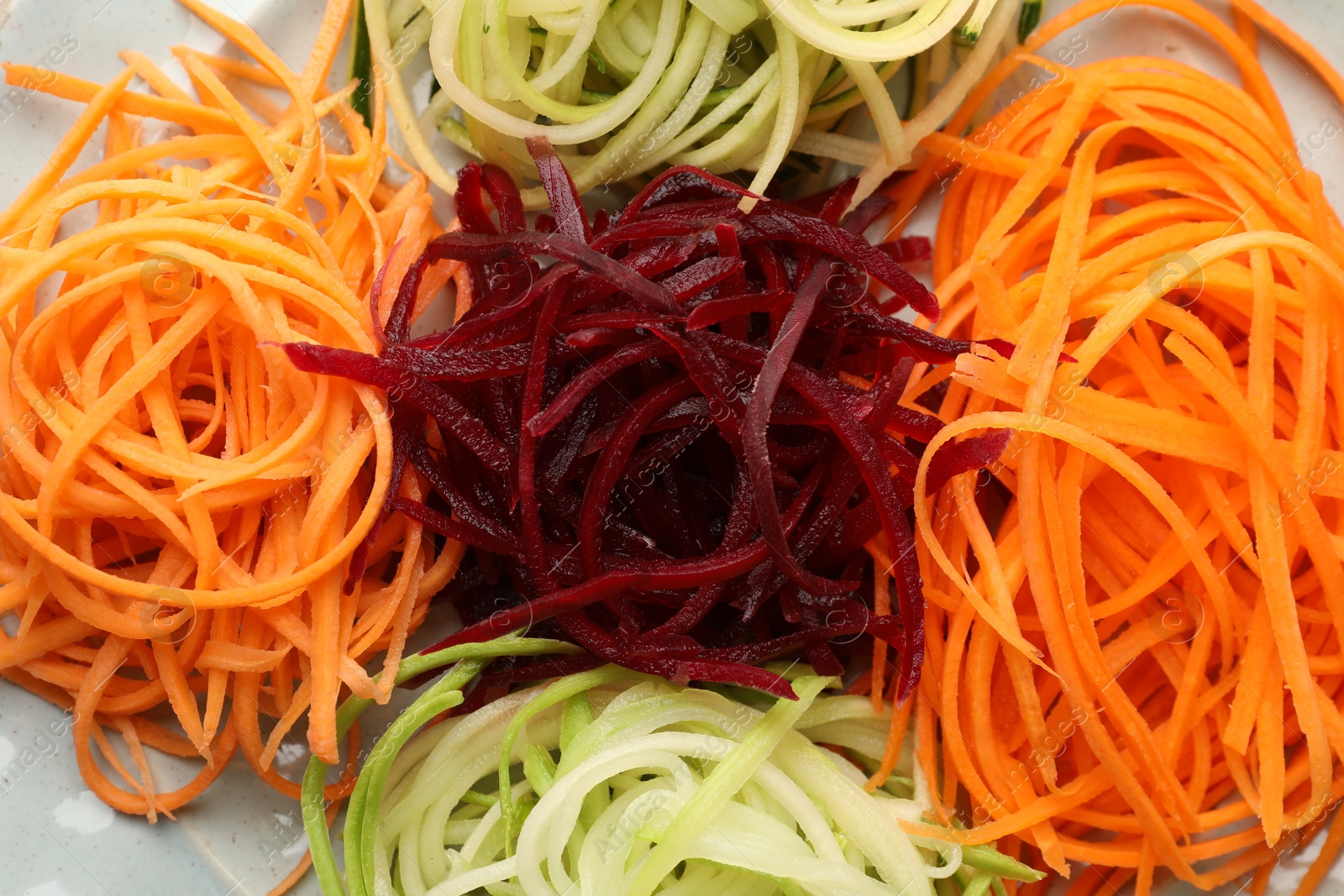 Photo of Different fresh vegetable noodles on plate, closeup