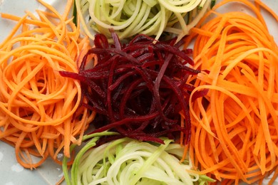 Photo of Different fresh vegetable noodles on plate, closeup