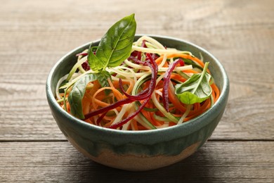 Photo of Tasty vegetable noodles on wooden table, closeup