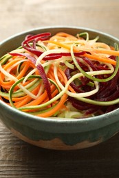 Photo of Tasty vegetable noodles on wooden table, closeup