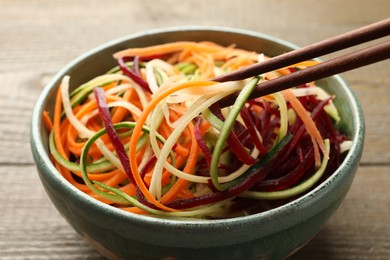 Photo of Tasty vegetable noodles served on wooden table, closeup