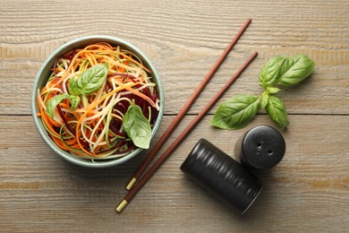 Photo of Tasty vegetable noodles served on wooden table, flat lay