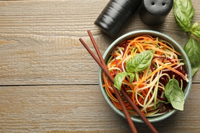 Photo of Tasty vegetable noodles served on wooden table, flat lay. Space for text