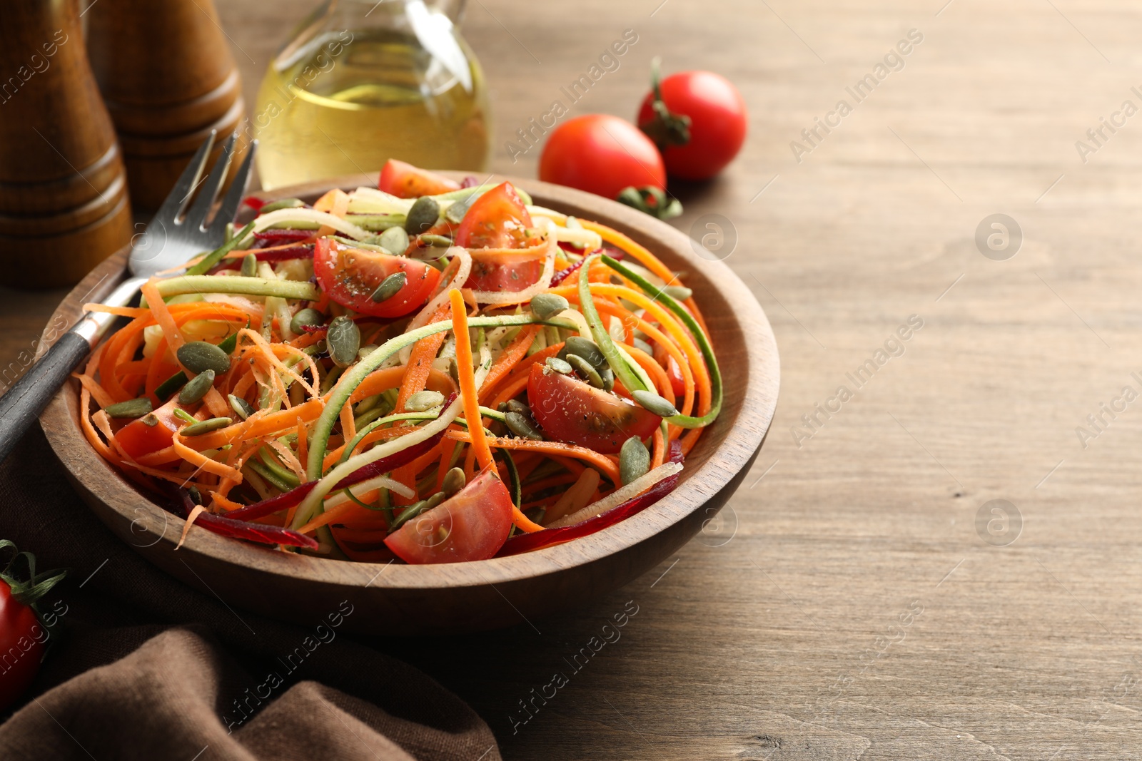 Photo of Tasty vegetable noodles served on wooden table, closeup