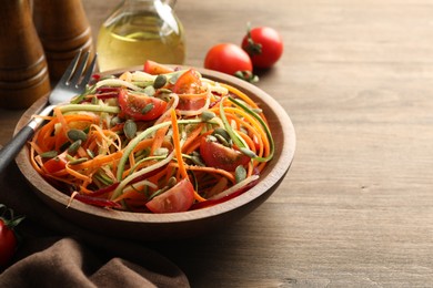 Photo of Tasty vegetable noodles served on wooden table, closeup