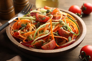 Photo of Tasty vegetable noodles served on wooden table, closeup