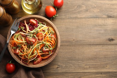 Photo of Tasty vegetable noodles served on wooden table, flat lay. Space for text