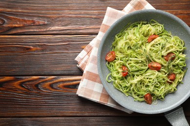 Photo of Tasty zucchini noodles with tomatoes and thyme on wooden table, top view. Space for text