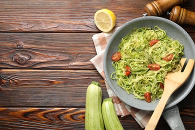 Photo of Tasty zucchini noodles with tomatoes, thyme and ingredients on wooden table, flat lay. Space for text