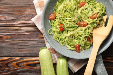 Photo of Tasty zucchini noodles with tomatoes and thyme on wooden table, top view