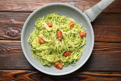 Photo of Tasty zucchini noodles with tomatoes and thyme on wooden table, top view