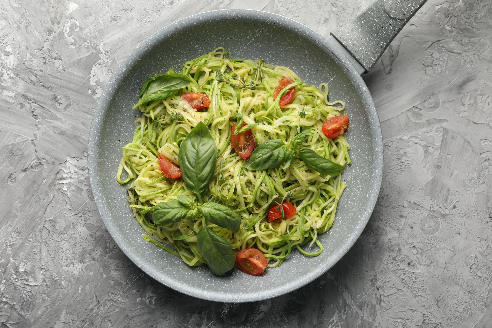 Tasty zucchini noodles with tomatoes and basil, top view Photo of Tasty zucchini noodles with tomatoes and basil, top view